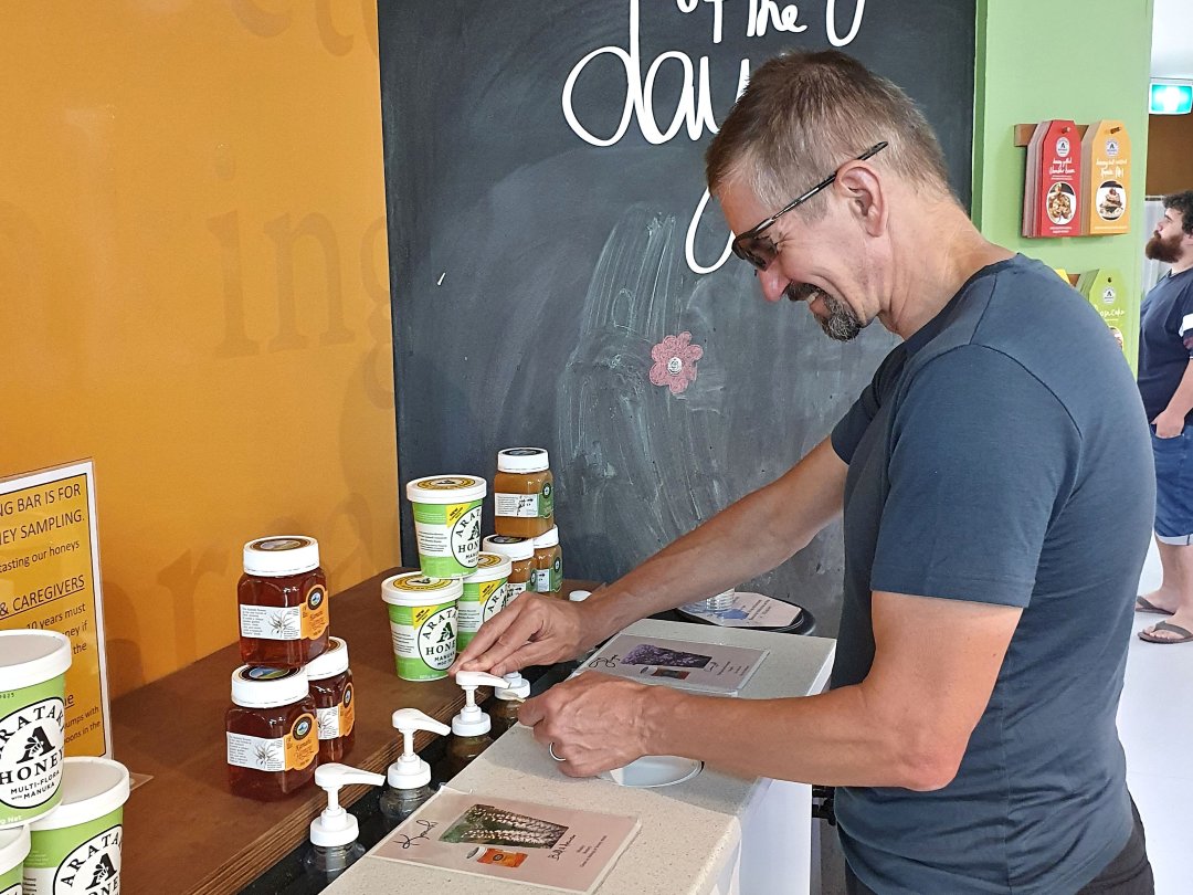 Man sampling honey at tasting bar