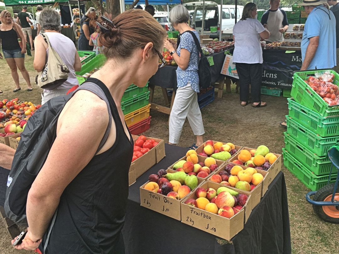 Woman browsing fruit at outdoor farmers market