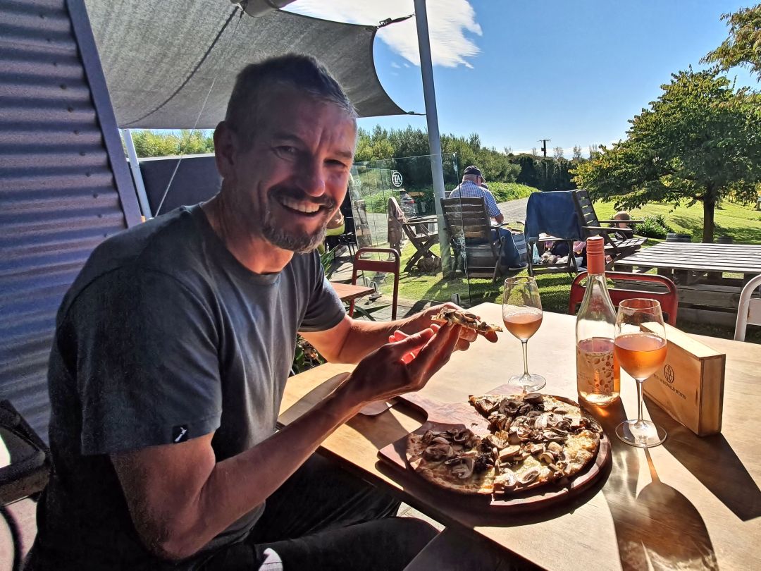 Paul enjoying mushroom pizza and rosé outdoors