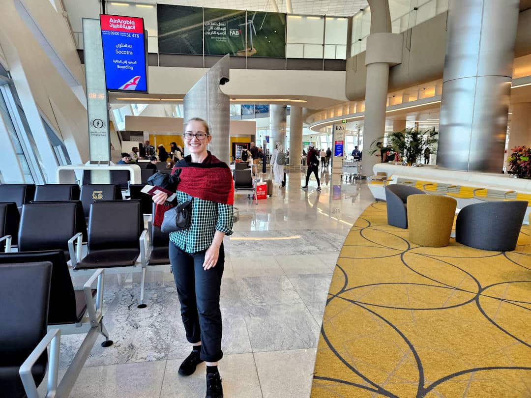 Traveler at airport terminal near seating area.