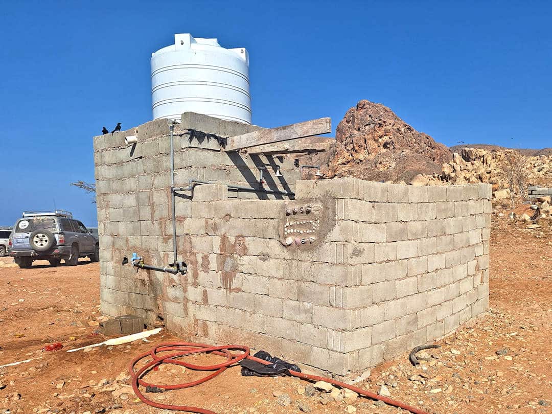 bathroom at detwah campsite Cinder block water tank with blue sky background.