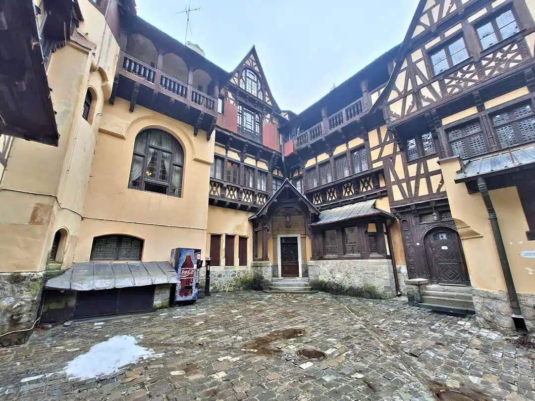 Courtyard of Pelișor Castle with Timber Architecture and Vending Machine