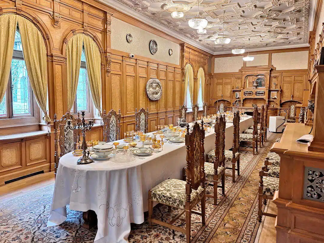 Elegant Dining Room at Pelișor Castle with Carved Chairs and Set Table