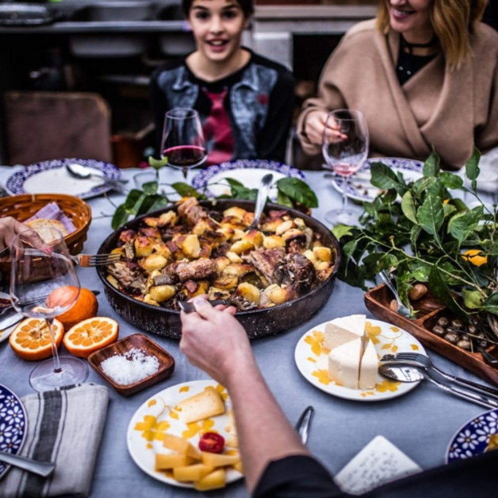 Friends and family sharing a traditional meal around a table — an EatWith dining experience.