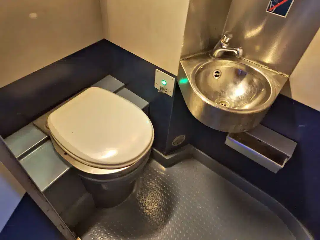 Ensuite bathroom in sleeper cabin Compact airplane lavatory with toilet and sink.