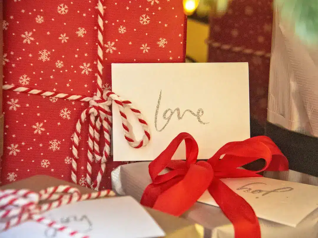 Wrapped gifts with love card and red ribbons.