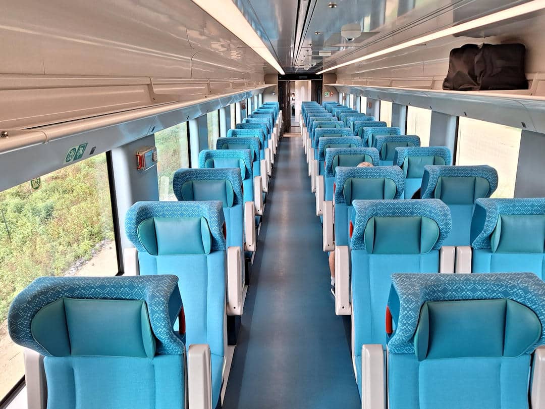 interior premier class tren maya Modern and spacious turquoise Premier Class seats inside the Tren Maya train carriage, with large windows and overhead storage