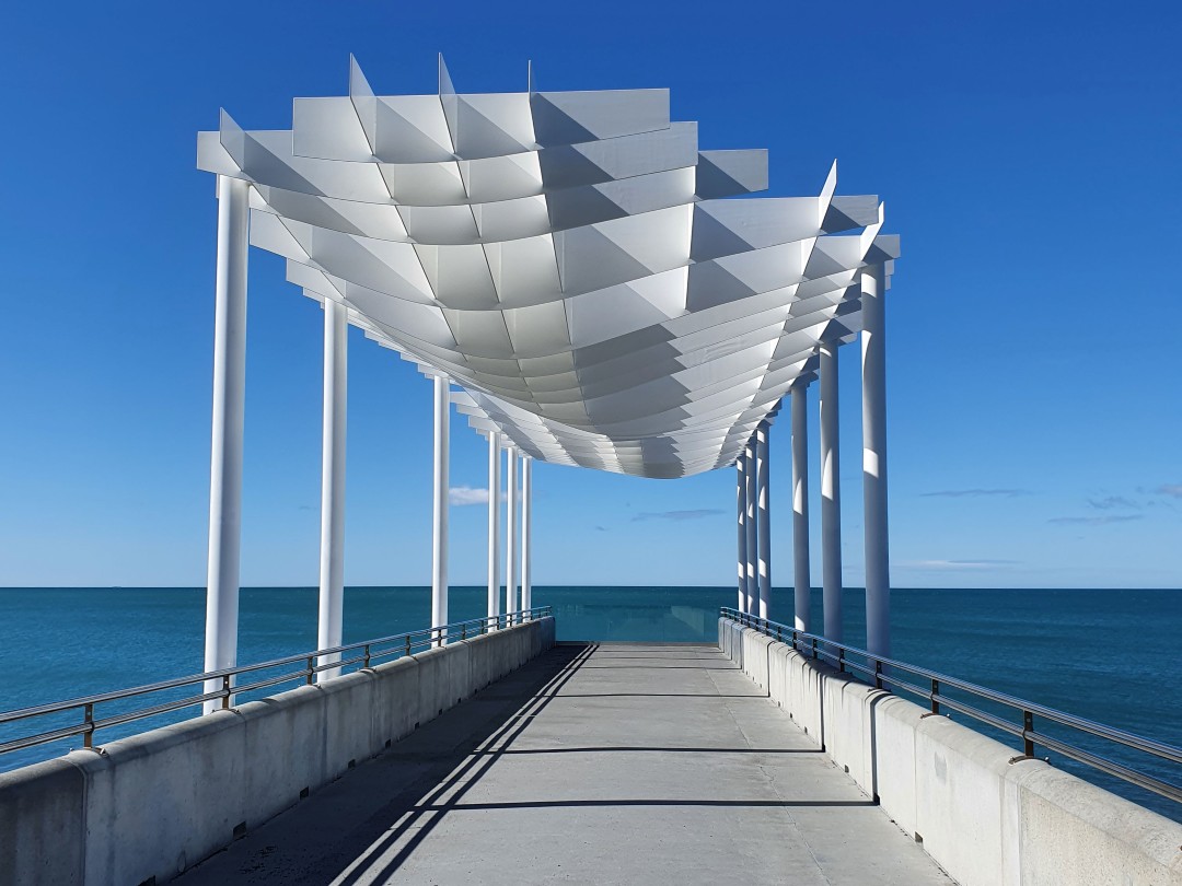 Modern white canopy over ocean pier walkway