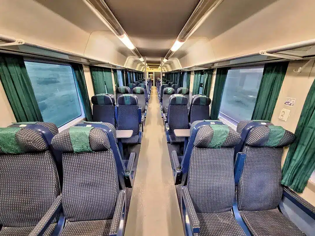 Open compartment on overnight train Empty train carriage with seats and windows.