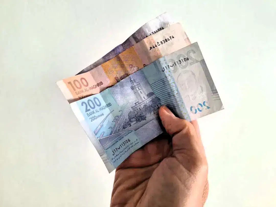 Hand holding Moroccan dirham banknotes