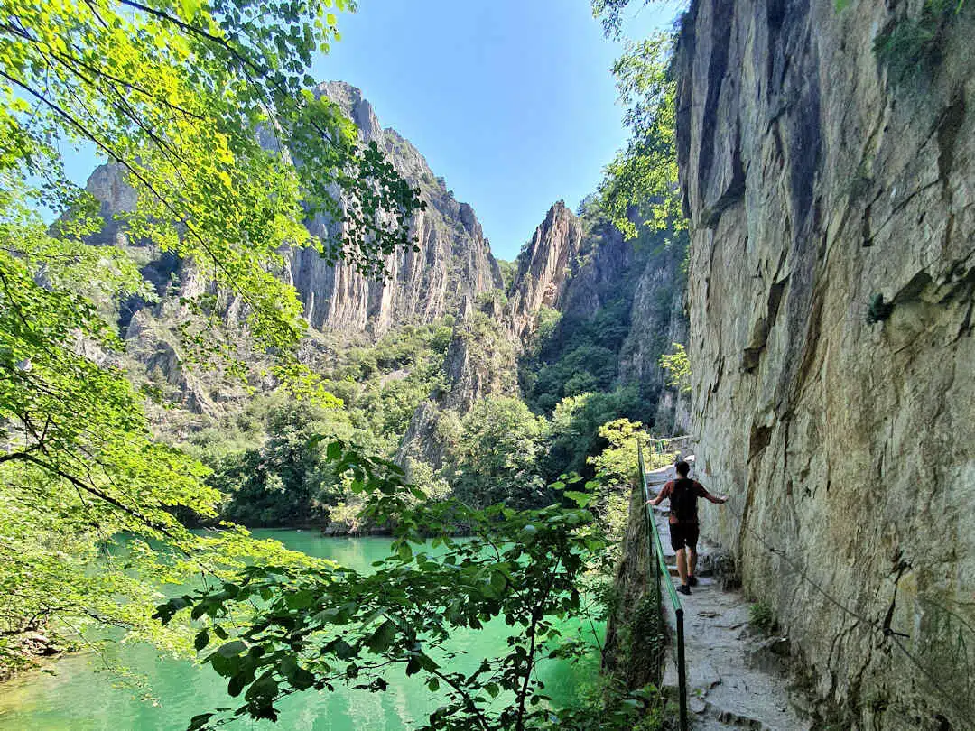 paul on matka canyon trail Traveller hiking the narrow cliffside trail above the emerald waters of Matka Canyon in North Macedonia