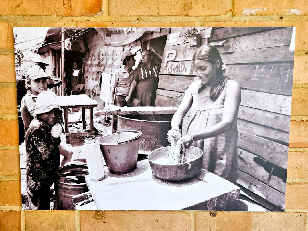 photo of moravia inhabitant at the cultural development centre Historic photo of Moravia residents preparing food outside makeshift homes, illustrating life before Medellín’s community transformation.
