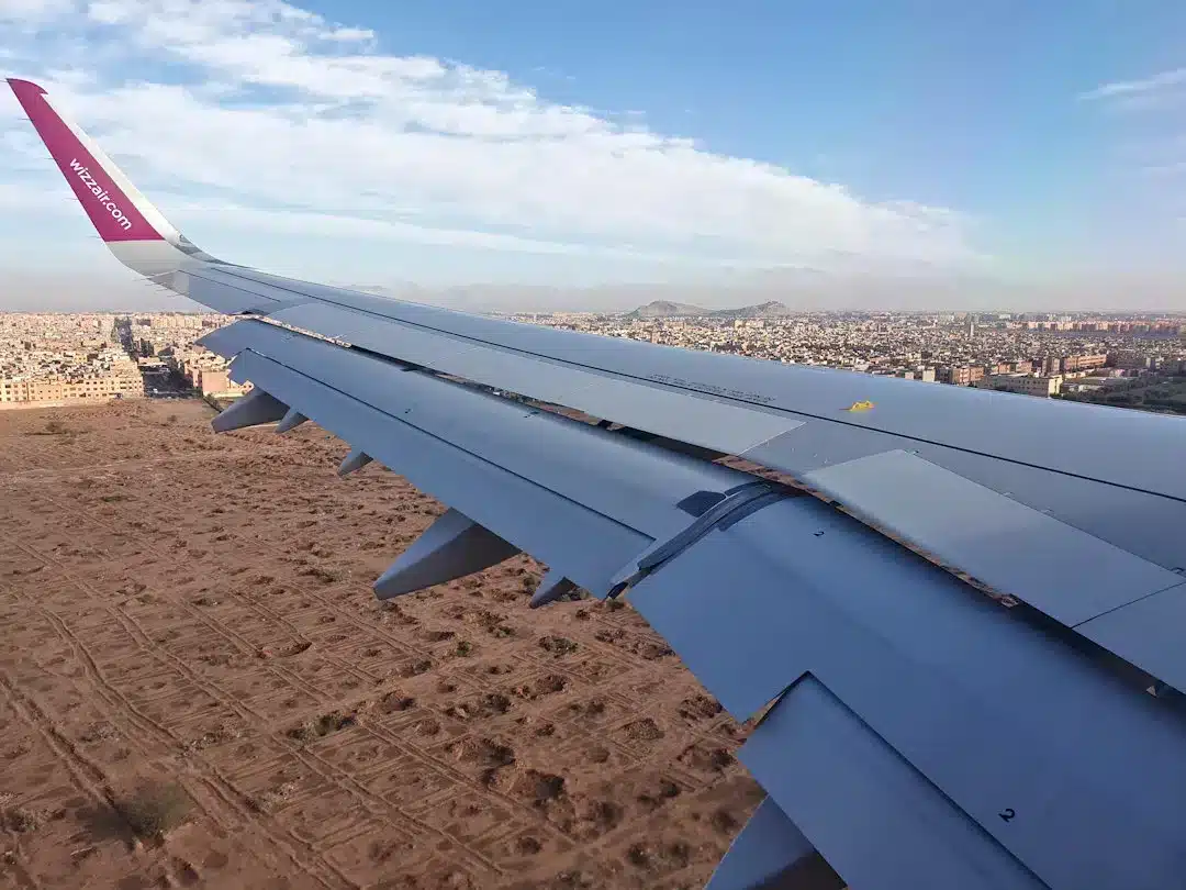 Airplane wing over urban landscape during flight.