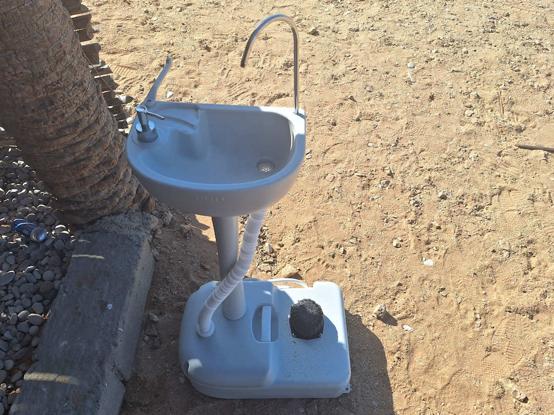 portable wash basin Portable outdoor sink in a sandy area.