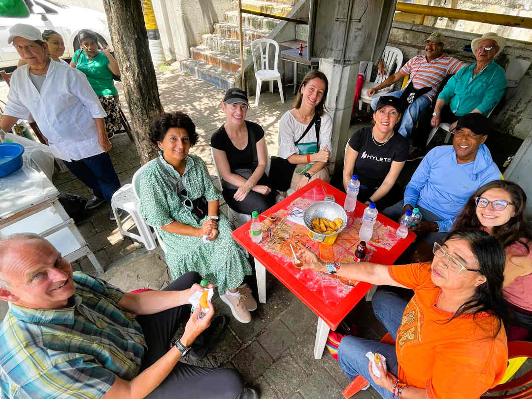real city tour group at lunch stop Tour group enjoying snacks and conversation with Moravia residents during the Comuna 4 Barrio Transformation Tour