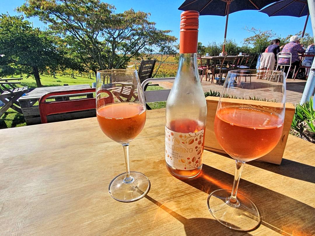 Two glasses of ros&eacute; wine on vineyard patio table
