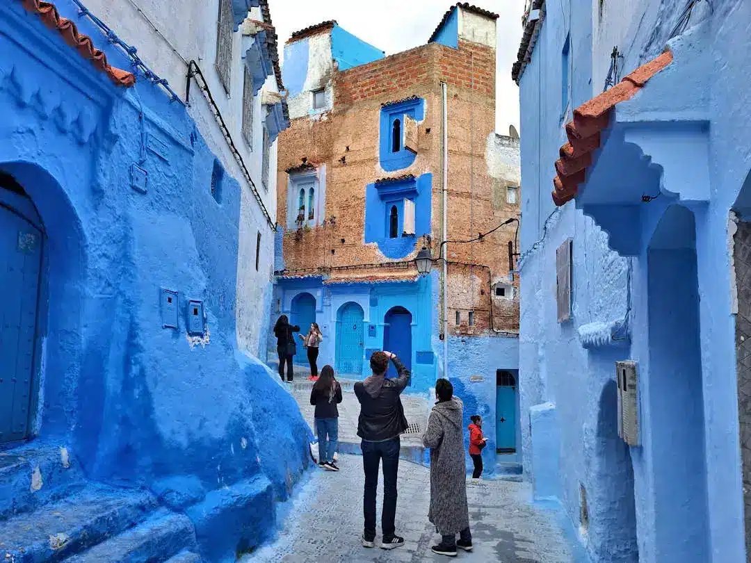 People in blue-painted alley, Chefchaouen, Morocco