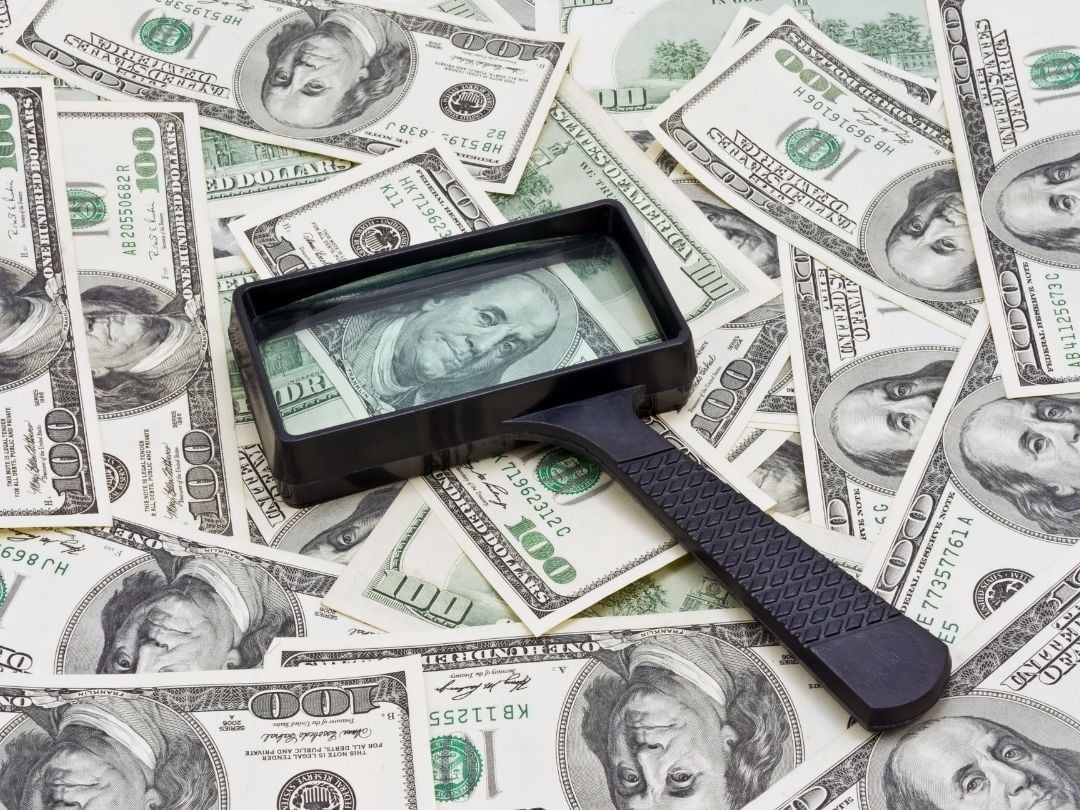 us dollars and magnifying glass