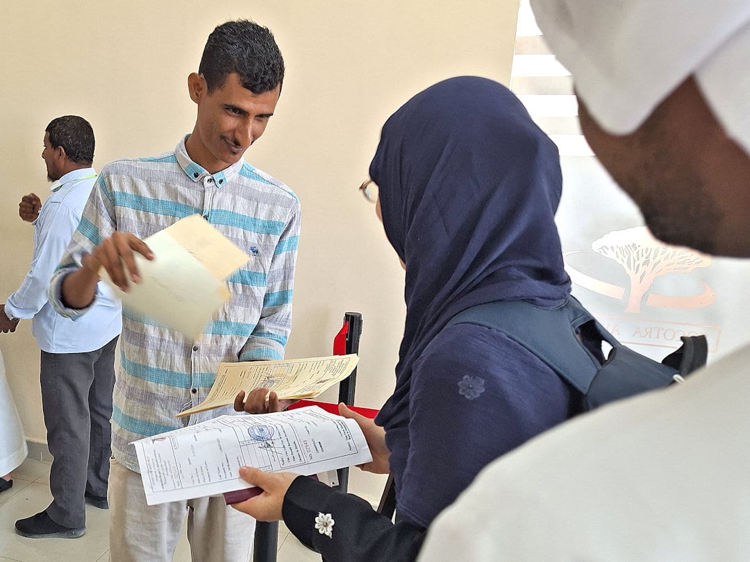 visa check at socotra airport People exchanging documents at an office.