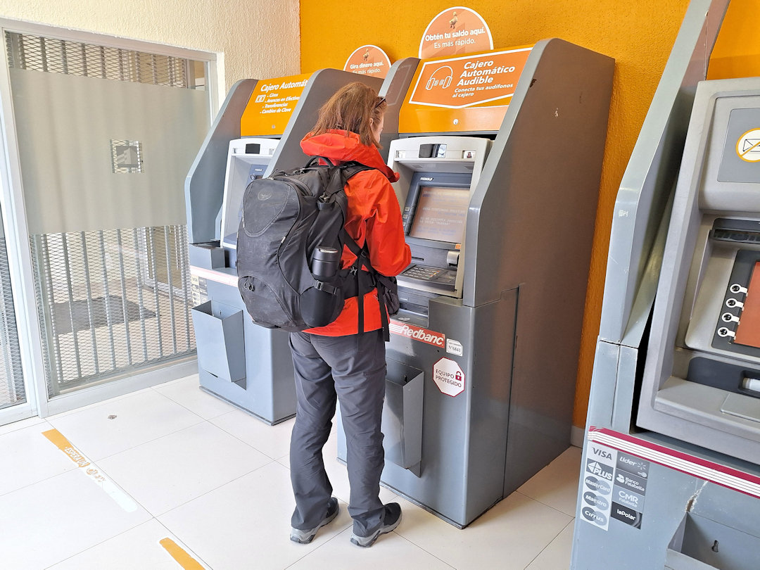 Sandra using a BancoEstado ATM in Puerto Natales to withdraw Chilean pesos.